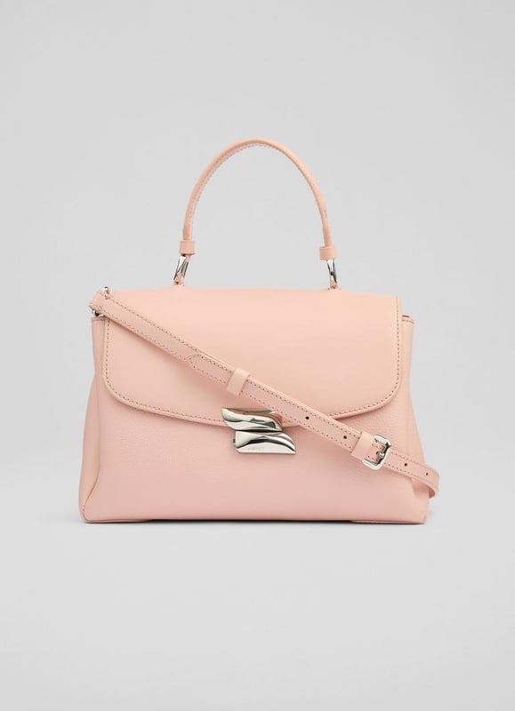 The Darcie shoulder bag promises to be your new favourite daytime companion. Fashioned from luxurious pink leather, this top-handle crossbody showcases new branding and a 100% cotton lining, embodying sophistication with every detail. Perfect for a brunch date or adding flair to your everyday jeans and blouse ensemble.