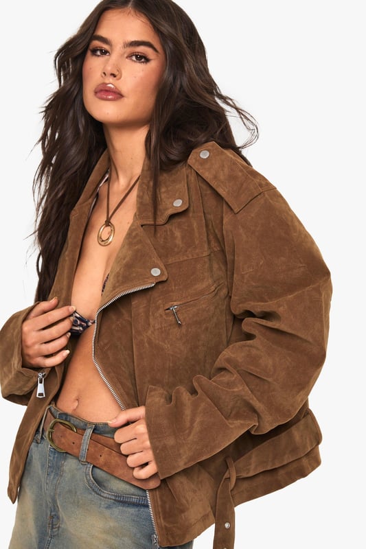 Oversized biker jacket in faux suede for a bold, edgy look
        Asymmetrical zip front closure for a modern twist
        Notched lapels and epaulettes for classic biker style
        Belted hem for adjustable fit and added flair
        Multiple pockets for both style and functionality
    
    Make a statement with this oversized biker jacket that combines timeless style with contemporary flair. The faux suede fabric offers a luxurious look and feel, perfect for those seeking a cruelty-free alternative. Its relaxed fit allows for easy layering, making it ideal for transitional weather. Style it with a simple white tee and denim shorts for a casual daytime look, or throw it over a floral dress for an edgy contrast at informal gatherings. For cooler evenings, pair with skinny jeans and ankle boots to create a sleek silhouette. The versatile nature of this jacket makes it a go-to piece for various casual occasions, from coffee dates to family barbecues. Its ability to effortlessly elevate any outfit ensures you'll stand out whilst remaining comfortably on-trend.