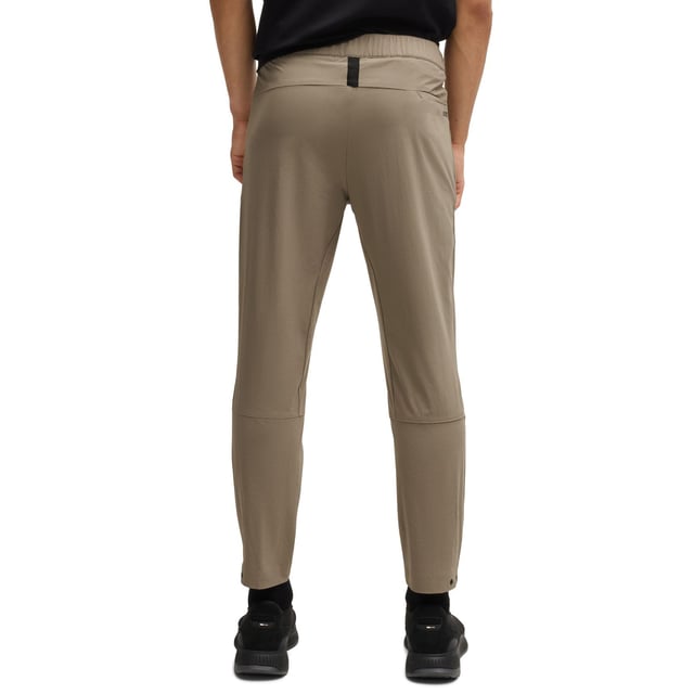 Mens BOSS T Basin Tapered-leg trousers in water-repellent stretch fabric in beigeThese BOSS Menswear tapered-fit trousers have adjustability at the waist and hems. Expand your wardrobe with this versatile pair crafted in stretch material with water repellency.- Elasticated waistband with inner drawcord- Zipped front pockets- Tapered leg- Snap buttons on hem- Technical 4-way stretch for maximum freedom of movement- Quick-dry  water-repellent and easy iron.- Main material: 90% Polyamide  10% Elastane.  Pocketing: 100% Polyester.  Machine washable.- Ref: 50529668-334