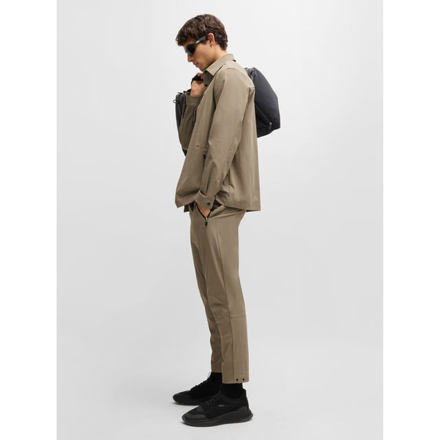 Mens BOSS T Basin Tapered-leg trousers in water-repellent stretch fabric in beigeThese BOSS Menswear tapered-fit trousers have adjustability at the waist and hems. Expand your wardrobe with this versatile pair crafted in stretch material with water repellency.- Elasticated waistband with inner drawcord- Zipped front pockets- Tapered leg- Snap buttons on hem- Technical 4-way stretch for maximum freedom of movement- Quick-dry  water-repellent and easy iron.- Main material: 90% Polyamide  10% Elastane.  Pocketing: 100% Polyester.  Machine washable.- Ref: 50529668-334