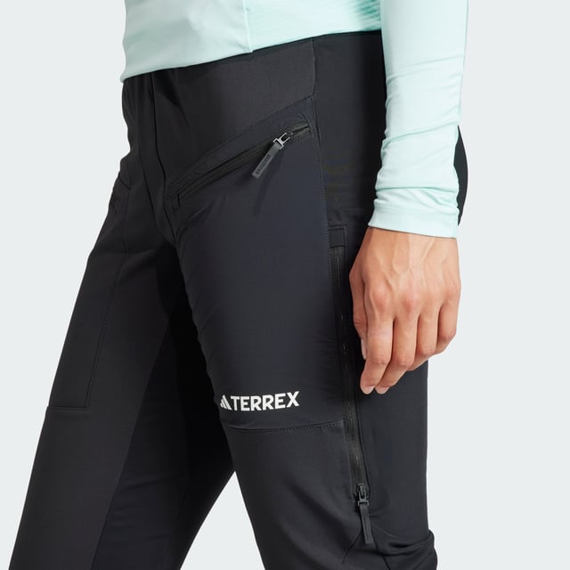 Snowshoeing, ski touring or hiking, these adidas mountain pants keep you warm without adding bulk. Cut for a slim fit and made from a combination of soft shell and stretch fabrics, they offer unrestricted range of motion. Secure the fit around your boots with the zip-adjustable cuffs to seal out dirt or snow. Side vents keep the air flowing to help regulate your temperature when you're out exploring in the elements.  - Slim fit - Drawcord on elastic waist - 100% polyester (recycled) - Thigh pockets with zip - Side vents with zip - Zip-adjustable cuffs with gusset and snap-button closure  Shipped by adidas
