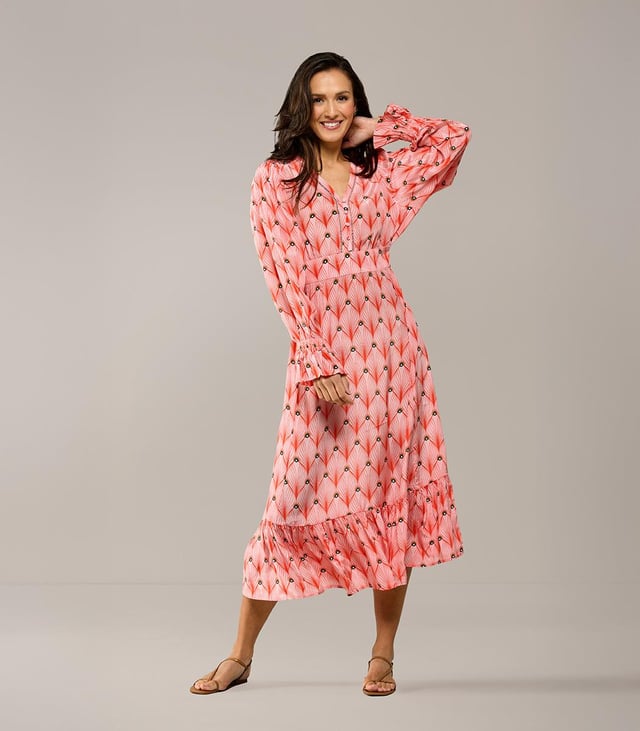 Die neue Kollektion von Caroline Tensen umfasst das wunderschöne Kleid mit Aberdeen-Print, ein Must-have für den Sommer. Die weiche, weite Passform mit besonderen Details verleiht dem Kleid einen schicken und zugleich lässigen Look. Der auffällige Pfauendruck in Orange, kombiniert mit dem korallenrosa Hintergrund, macht das Kleid wirklich einzigartig. Die langen Ärmel haben einen dezenten Balloneffekt und enden in einer verspielten Rüsche mit elastischem Abschluss. Das Kleid hat einen V-Ausschnitt mit durchbrochenem Besatz. Die gerade Ausführung sorgt für ein angenehmes Tragegefühl. Das Kleid verfügt außerdem über einen festen Bindegürtel, sodass die Taille schön betont werden kann. Der untere Teil des Kleides hat eine horizontale Naht mit Falten für einen elegant fließenden Effekt. Dieser besondere Druck ist auch in einer raffinierten Tunika erhältlich!