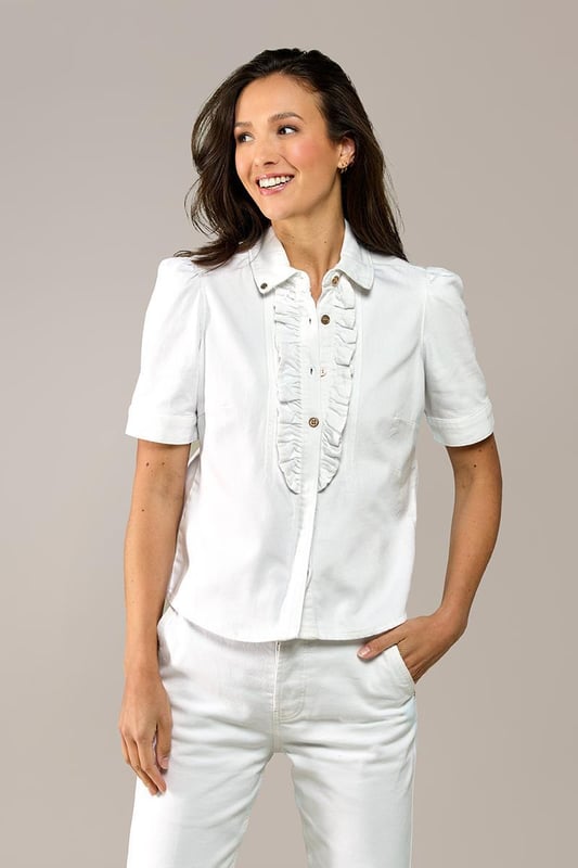 Kies deze zomer voor een blouse met een denim-look! Dit mooie blousje uit mijn nieuwste collectie is de ideale basis voor een stijlvolle outfit. De blouse in een frisse witte tint heeft korte pofmouwen en een chique hoge kraag. De knoopsluiting in het midden is voorzien van een speelse ruche, die de blouse een unieke uitstraling geeft. Door de getailleerde pasvorm en de lengte tot op de heup, komt je vrouwelijke silhouet prachtig tot zijn recht. Gemaakt van biologisch katoen, biedt deze witte blouse niet alleen stijl, maar ook optimaal comfort. Het stretchdenim past zich perfect aan je lichaam aan. Verkrijgbaar in verschillende kleuren: ontdek ook de Brighton denim blouse in mediumblauw en lichtblauw.