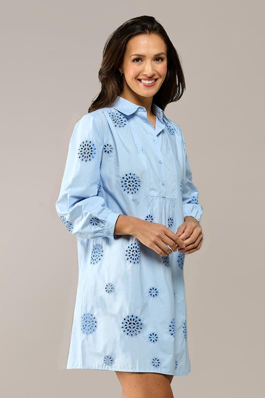 Entdecken Sie den raffinierten Charme der Manchester-Tunika, einer hellblauen Tunika mit zarter Stickerei für einen sommerlichen Look. Diese Damentunika aus leichter Baumwolle verfügt über dezente grafische Details, die dem Design eine besondere Note verleihen. Der Reverskragen und die blauen Knöpfe entlang der Knopfleiste sorgen für ein elegantes Finish. Die Dreiviertelärmel sind mit einem verspielten Rüscheneffekt am Handgelenk verziert und auf der Rückseite befindet sich eine leichte Falte für zusätzliche Bewegungsfreiheit. Die Tunika Manchester hat eine bequeme, ausgestellte Passform und bietet die Möglichkeit, sie mit oder ohne Gürtel zu tragen, für eine straffere Silhouette oder einen entspannten, lockeren Look. Ein zeitloses Favorit, das Sie immer wieder tragen werden!