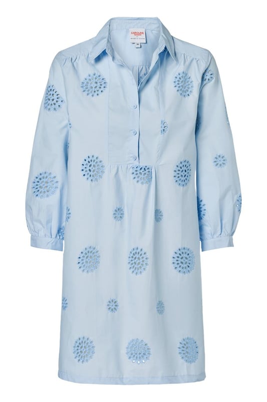 Entdecken Sie den raffinierten Charme der Manchester-Tunika, einer hellblauen Tunika mit zarter Stickerei für einen sommerlichen Look. Diese Damentunika aus leichter Baumwolle verfügt über dezente grafische Details, die dem Design eine besondere Note verleihen. Der Reverskragen und die blauen Knöpfe entlang der Knopfleiste sorgen für ein elegantes Finish. Die Dreiviertelärmel sind mit einem verspielten Rüscheneffekt am Handgelenk verziert und auf der Rückseite befindet sich eine leichte Falte für zusätzliche Bewegungsfreiheit. Die Tunika Manchester hat eine bequeme, ausgestellte Passform und bietet die Möglichkeit, sie mit oder ohne Gürtel zu tragen, für eine straffere Silhouette oder einen entspannten, lockeren Look. Ein zeitloses Favorit, das Sie immer wieder tragen werden!