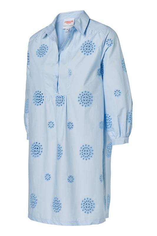 Entdecken Sie den raffinierten Charme der Manchester-Tunika, einer hellblauen Tunika mit zarter Stickerei für einen sommerlichen Look. Diese Damentunika aus leichter Baumwolle verfügt über dezente grafische Details, die dem Design eine besondere Note verleihen. Der Reverskragen und die blauen Knöpfe entlang der Knopfleiste sorgen für ein elegantes Finish. Die Dreiviertelärmel sind mit einem verspielten Rüscheneffekt am Handgelenk verziert und auf der Rückseite befindet sich eine leichte Falte für zusätzliche Bewegungsfreiheit. Die Tunika Manchester hat eine bequeme, ausgestellte Passform und bietet die Möglichkeit, sie mit oder ohne Gürtel zu tragen, für eine straffere Silhouette oder einen entspannten, lockeren Look. Ein zeitloses Favorit, das Sie immer wieder tragen werden!