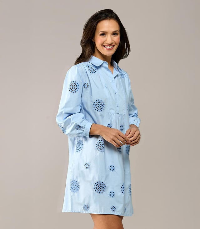Entdecken Sie den raffinierten Charme der Manchester-Tunika, einer hellblauen Tunika mit zarter Stickerei für einen sommerlichen Look. Diese Damentunika aus leichter Baumwolle verfügt über dezente grafische Details, die dem Design eine besondere Note verleihen. Der Reverskragen und die blauen Knöpfe entlang der Knopfleiste sorgen für ein elegantes Finish. Die Dreiviertelärmel sind mit einem verspielten Rüscheneffekt am Handgelenk verziert und auf der Rückseite befindet sich eine leichte Falte für zusätzliche Bewegungsfreiheit. Die Tunika Manchester hat eine bequeme, ausgestellte Passform und bietet die Möglichkeit, sie mit oder ohne Gürtel zu tragen, für eine straffere Silhouette oder einen entspannten, lockeren Look. Ein zeitloses Favorit, das Sie immer wieder tragen werden!
