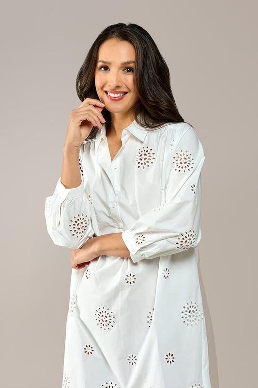 Ontdek het verfijnde ontwerp van de Manchester tuniek, een witte tuniek met broderie voor een zomerse uitstraling. Gemaakt van luchtig katoen, biedt deze witte damestuniek een subtiele grafische afwerking die zorgt voor een unieke look. De reverskraag en de witte knoopjes langs de placket geven de tuniek een elegante flair. De driekwartmouwen zijn versierd met een licht ruche-effect bij de pols, en de achterkant heeft een lichte plooiing voor extra bewegingsvrijheid. De Manchester tuniek heeft een uitlopende pasvorm en een klassieke kraag. Voeg een ceintuur toe voor een prachtig zandloper-silhouet of draag hem los voor een ontspannen look. Een tijdloze favoriet die je keer op keer zult dragen!