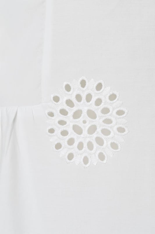 Ontdek het verfijnde ontwerp van de Manchester tuniek, een witte tuniek met broderie voor een zomerse uitstraling. Gemaakt van luchtig katoen, biedt deze witte damestuniek een subtiele grafische afwerking die zorgt voor een unieke look. De reverskraag en de witte knoopjes langs de placket geven de tuniek een elegante flair. De driekwartmouwen zijn versierd met een licht ruche-effect bij de pols, en de achterkant heeft een lichte plooiing voor extra bewegingsvrijheid. De Manchester tuniek heeft een uitlopende pasvorm en een klassieke kraag. Voeg een ceintuur toe voor een prachtig zandloper-silhouet of draag hem los voor een ontspannen look. Een tijdloze favoriet die je keer op keer zult dragen!