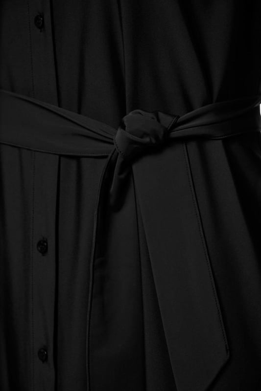 Dieses durchgehende Kleid mit Knopfleiste aus der neuesten Kollektion von Mart Visser ist ein echtes Must-have für jede Garderobe. Das zeitlose und elegante Design macht dieses Kleid alltagstauglich. Das schwarze Kleid aus weichem Reisestoff bietet sowohl Komfort als auch Bewegungsfreiheit. Mit dem passenden Bindegürtel gelingt dir ganz einfach die perfekte Passform. Das Kleid hat praktische Seitentaschen, einen klassischen Reverskragen und elastische Details an den Ärmeln, die einen dezenten Rüscheneffekt erzeugen. Die gerade Passform des Kleides fällt elegant bis zur Wade. Darüber hinaus lässt sich das Kleid offen als Longbluse tragen, kombiniert mit Jeans und einem stylischen Top oder einem Basic-Unterhemd. Suchen Sie nach einer anderen Farbe? Dann schau dir auch die marineblaue Version dieses wunderschönen Kleides an! Das schwarze durchgehende Kleid ist die perfekte Ergänzung Ihrer Garderobe und eine echte Investition für die Zukunft.