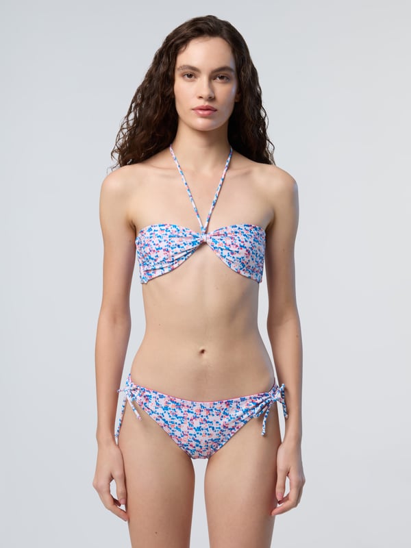 Ein Bikinioberteil, endlose Vielseitigkeit. Dieses wendbare Modell ist auf einer Seite bedruckt und auf der anderen einfarbig. Es besteht aus recycelter Nylon-Mikrofaser und sorgt für ein leichtes Tragegefühl und einen noch geringeren Platzbedarf. Die schicke Bandeau-Silhouette kann flach getragen, in der Mitte gerafft oder im Nacken gebunden werden.