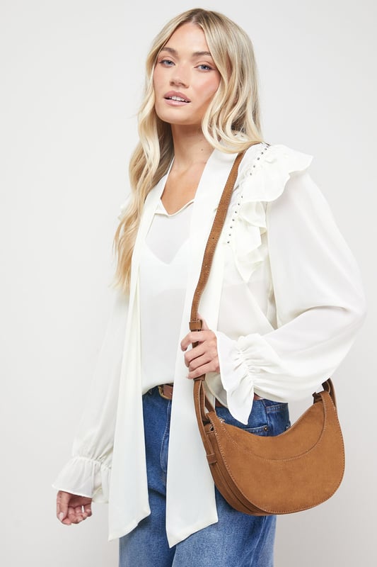 Distinctive half-moon silhouette for a contemporary aesthetic
        Soft faux suede texture adds a luxurious touch to casual outfits
        Adjustable crossbody strap for comfortable all-day wear
        Secure zip-top closure to keep essentials safe
        Compact yet spacious enough for daily necessities
    
    The Relly Faux Suede Half Moon Crossbody Bag combines practicality with feminine charm, embodying Oasis's signature style. The curved silhouette creates a soft, modern look that pairs beautifully with both casual and smart-casual ensembles. Style with relaxed denim and a floaty blouse for daytime outings, or match with a floral day dress for garden parties and family gatherings. The versatile design makes it perfect for weekend shopping trips, coffee dates, or casual lunches. The adjustable strap allows for customised wear, while the interior provides just enough room for your phone, wallet, keys and lipstick. This bag effortlessly transitions from day to evening, making it an essential addition to your accessory collection for those moments when you want to travel light without compromising on style.