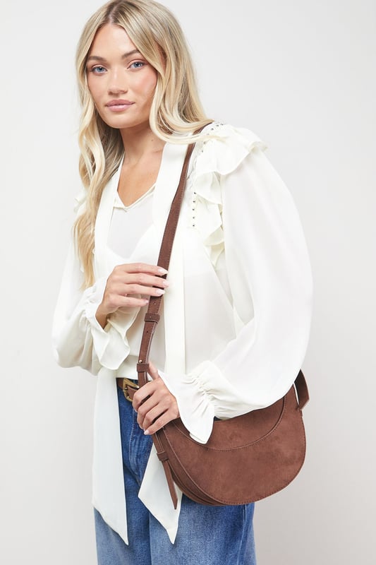 Distinctive half-moon silhouette for a contemporary aesthetic
        Soft faux suede texture adds a luxurious touch to casual outfits
        Adjustable crossbody strap for comfortable all-day wear
        Secure zip-top closure to keep essentials safe
        Compact yet spacious enough for daily necessities
    
    The Relly Faux Suede Half Moon Crossbody Bag combines practicality with feminine charm, embodying Oasis's signature style. The curved silhouette creates a soft, modern look that pairs beautifully with both casual and smart-casual ensembles. Style with relaxed denim and a floaty blouse for daytime outings, or match with a floral day dress for garden parties and family gatherings. The versatile design makes it perfect for weekend shopping trips, coffee dates, or casual lunches. The adjustable strap allows for customised wear, while the interior provides just enough room for your phone, wallet, keys and lipstick. This bag effortlessly transitions from day to evening, making it an essential addition to your accessory collection for those moments when you want to travel light without compromising on style.