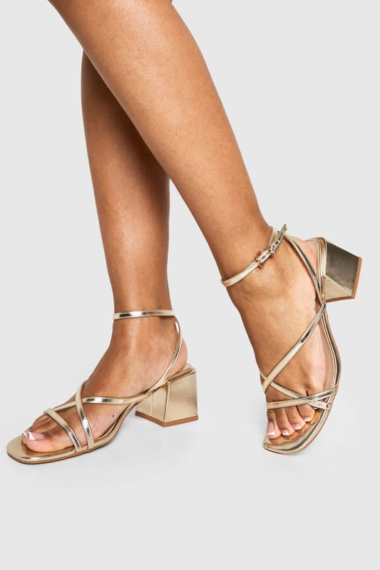 Metallic Crossover Strap Detail Low Block Heels Elegant crossover strap design for a contemporary twist on classic sandals
Comfortable low block heel measuring between 2.5-4.5cm for all-night wearability
Metallic finish that catches the light beautifully as you move
Adjustable ankle strap with secure buckle fastening
Versatile square toe silhouette that complements various outfits
These striking metallic heels strike the perfect balance between style and comfort, featuring delicate crossover straps that create a flattering effect on the foot. The low block heel provides stability whilst adding just enough height to enhance your silhouette without compromising on comfort during those long nights out. Pair with a sleek mini dress and statement earrings for an evening at the club, or style with tailored trousers and a silky camisole when meeting friends for cocktails. The ankle strap ensures a secure fit as you dance the night away, whilst the metallic finish adds a touch of glamour to any ensemble. These versatile heels transition effortlessly from day to night, making them an essential addition to your footwear collection for any social occasion where you want to make an impression without sacrificing comfort.