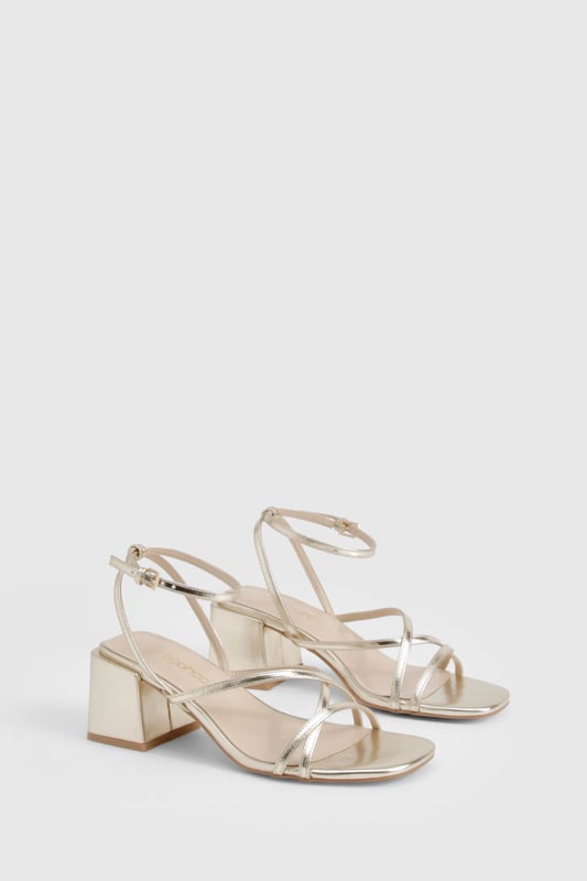 Metallic Crossover Strap Detail Low Block Heels Elegant crossover strap design for a contemporary twist on classic sandals
Comfortable low block heel measuring between 2.5-4.5cm for all-night wearability
Metallic finish that catches the light beautifully as you move
Adjustable ankle strap with secure buckle fastening
Versatile square toe silhouette that complements various outfits
These striking metallic heels strike the perfect balance between style and comfort, featuring delicate crossover straps that create a flattering effect on the foot. The low block heel provides stability whilst adding just enough height to enhance your silhouette without compromising on comfort during those long nights out. Pair with a sleek mini dress and statement earrings for an evening at the club, or style with tailored trousers and a silky camisole when meeting friends for cocktails. The ankle strap ensures a secure fit as you dance the night away, whilst the metallic finish adds a touch of glamour to any ensemble. These versatile heels transition effortlessly from day to night, making them an essential addition to your footwear collection for any social occasion where you want to make an impression without sacrificing comfort.