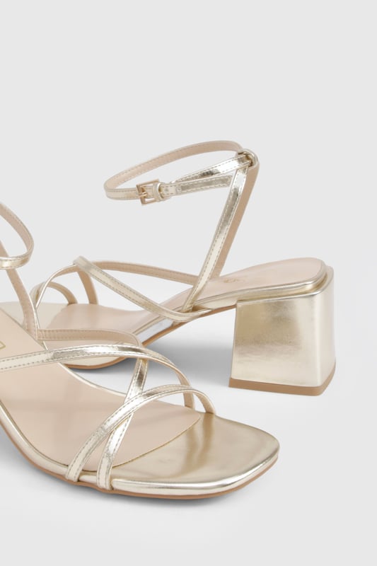 Metallic Crossover Strap Detail Low Block Heels Elegant crossover strap design for a contemporary twist on classic sandals
Comfortable low block heel measuring between 2.5-4.5cm for all-night wearability
Metallic finish that catches the light beautifully as you move
Adjustable ankle strap with secure buckle fastening
Versatile square toe silhouette that complements various outfits
These striking metallic heels strike the perfect balance between style and comfort, featuring delicate crossover straps that create a flattering effect on the foot. The low block heel provides stability whilst adding just enough height to enhance your silhouette without compromising on comfort during those long nights out. Pair with a sleek mini dress and statement earrings for an evening at the club, or style with tailored trousers and a silky camisole when meeting friends for cocktails. The ankle strap ensures a secure fit as you dance the night away, whilst the metallic finish adds a touch of glamour to any ensemble. These versatile heels transition effortlessly from day to night, making them an essential addition to your footwear collection for any social occasion where you want to make an impression without sacrificing comfort.
