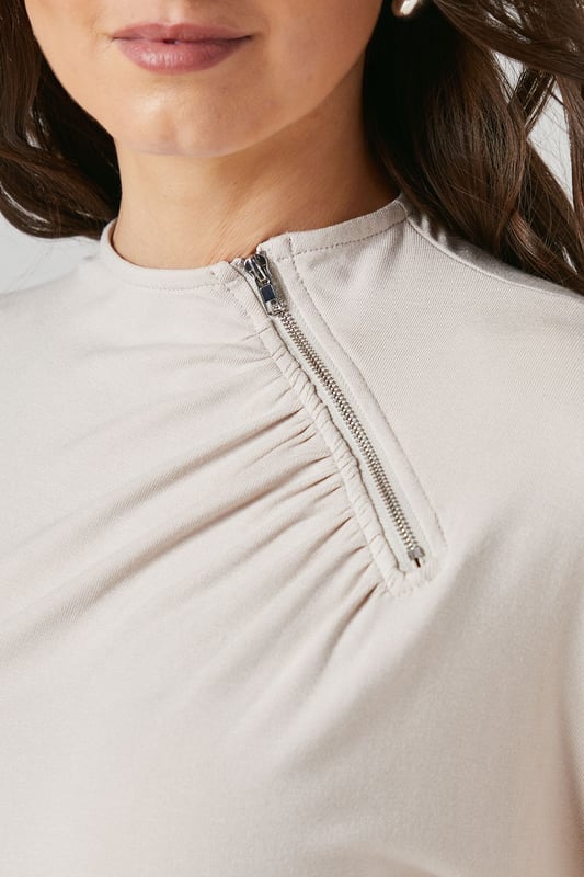 Elegant flutter sleeves for a soft, feminine silhouette
        Distinctive asymmetric zip detail adding contemporary flair
        Flattering crew neckline with subtle gathering detail
        Smooth jersey fabric offering comfortable stretch and movement
        Regular fit design perfect for versatile styling options
    
    This Principles top combines effortless style with practical comfort for your everyday wardrobe. The delicate flutter sleeves create a graceful drape while the unique asymmetric zip detail adds a modern twist to this otherwise classic piece. The gentle gathering at the neckline creates subtle texture and dimension that flatters your dcolletage. Style with wide-leg trousers as shown for a polished daytime look, perfect for family gatherings or weekend brunches. For casual outings, pair with your favourite denim and trainers, or dress up with tailored trousers and ballet flats for office wear. The stretchy jersey composition ensures all-day comfort without compromising on style, making this a versatile piece that transitions seamlessly from morning coffee runs to afternoon shopping trips.