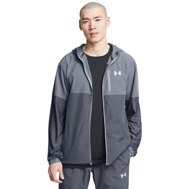 Under Armour Vanish Hybride Jas Grijs. Een lichtgewicht jack. Een over de hele breedte twee rijen ontwerp. Een volledige ritssluiting aan de voorkant met een verstelbare capuchon en een hoge kraag. Reflecterende banden op de schouders. Lange elastische manchetten aan de lange mouwen met het kenmerkende Under Armour-logo in wit opgedrukt. Twee zakken met ritssluiting in de taille en een zak met ritssluiting op de linkerborst met het kenmerkende Under Armour-logo in wit gegummeerd.