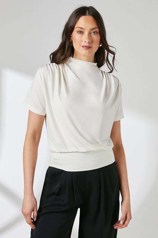 Elegant high neck design with sophisticated drape detail across the front
        Short sleeves with subtle gathering at the shoulders for added dimension
        Fitted ribbed hem creates a flattering silhouette
        Delicate keyhole fastening at the back for refined finishing
        Soft jersey fabric with gentle stretch for all-day comfort
    
    This versatile Principles top combines contemporary styling with everyday comfort. The graceful drape detail adds visual interest to the high neckline, whilst the fitted hem creates a polished, tucked-in appearance without the fuss. Perfect for daytime engagements, style with wide-leg trousers as shown for a balanced silhouette that works beautifully for family gatherings or weekend brunches. Alternatively, pair with tailored cigarette trousers and ballet flats for a smart-casual office look. The jersey fabric offers just the right amount of stretch to maintain its shape throughout the day, making this an ideal piece for your capsule wardrobe. Accessorise with statement earrings to draw attention to the elegant neckline and complete your effortlessly chic ensemble.