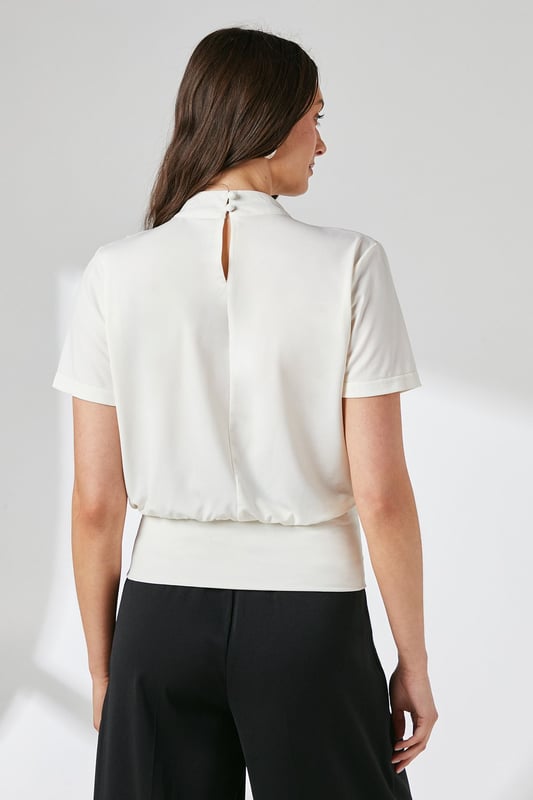 Elegant high neck design with sophisticated drape detail across the front
        Short sleeves with subtle gathering at the shoulders for added dimension
        Fitted ribbed hem creates a flattering silhouette
        Delicate keyhole fastening at the back for refined finishing
        Soft jersey fabric with gentle stretch for all-day comfort
    
    This versatile Principles top combines contemporary styling with everyday comfort. The graceful drape detail adds visual interest to the high neckline, whilst the fitted hem creates a polished, tucked-in appearance without the fuss. Perfect for daytime engagements, style with wide-leg trousers as shown for a balanced silhouette that works beautifully for family gatherings or weekend brunches. Alternatively, pair with tailored cigarette trousers and ballet flats for a smart-casual office look. The jersey fabric offers just the right amount of stretch to maintain its shape throughout the day, making this an ideal piece for your capsule wardrobe. Accessorise with statement earrings to draw attention to the elegant neckline and complete your effortlessly chic ensemble.