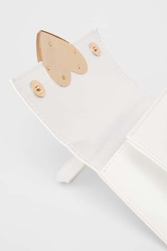 - Faux leather - Patent finish - Metal heart design - Top handle - Flap closure - Length: 5cm - Depth: 6cm - Height: 12.5cm approx - Excluding trims