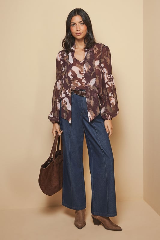 Elegant tie neck detail creates a sophisticated silhouette
        Dramatic balloon sleeves add a contemporary touch to this classic blouse
        Lightweight woven fabric ensures comfort throughout the day
        Versatile high neckline offers modest yet stylish coverage
        Flattering loose fit drapes beautifully for effortless wear
    
    This captivating floral blouse from Wallis combines timeless elegance with modern design elements. The statement tie neck and voluminous sleeves create a balanced silhouette that's both comfortable and chic. Style it as shown with wide-leg denim trousers and ankle boots for a sophisticated daytime look, perfect for lunch dates or family gatherings. For a more casual approach, pair with your favourite jeans and flat pumps. The versatile pattern works wonderfully with neutral accessories - try a structured handbag in a complementary tone to complete your ensemble. This blouse transitions seamlessly from office to weekend, making it an essential addition to your wardrobe that will serve you well for casual events and relaxed social occasions throughout the seasons.