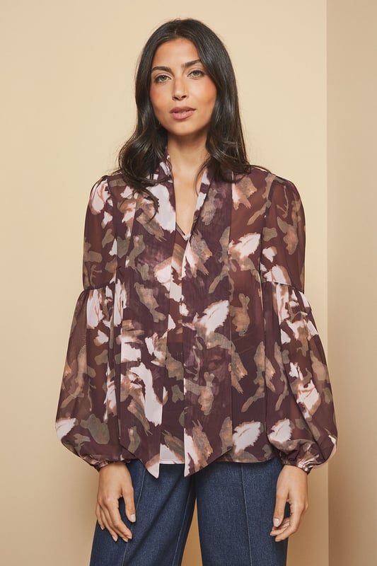 Elegant tie neck detail creates a sophisticated silhouette
        Dramatic balloon sleeves add a contemporary touch to this classic blouse
        Lightweight woven fabric ensures comfort throughout the day
        Versatile high neckline offers modest yet stylish coverage
        Flattering loose fit drapes beautifully for effortless wear
    
    This captivating floral blouse from Wallis combines timeless elegance with modern design elements. The statement tie neck and voluminous sleeves create a balanced silhouette that's both comfortable and chic. Style it as shown with wide-leg denim trousers and ankle boots for a sophisticated daytime look, perfect for lunch dates or family gatherings. For a more casual approach, pair with your favourite jeans and flat pumps. The versatile pattern works wonderfully with neutral accessories - try a structured handbag in a complementary tone to complete your ensemble. This blouse transitions seamlessly from office to weekend, making it an essential addition to your wardrobe that will serve you well for casual events and relaxed social occasions throughout the seasons.