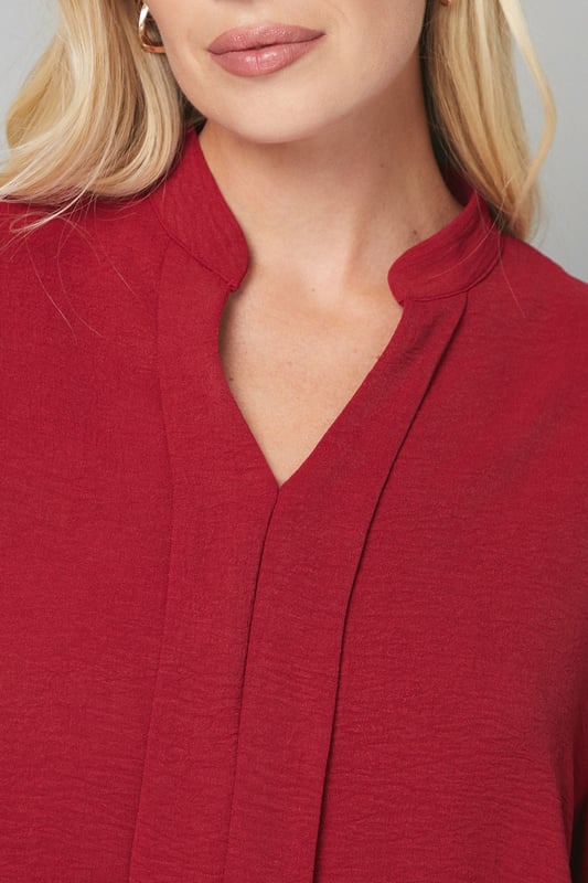 Elegant collarless design with a flattering V-neckline
        Relaxed silhouette with full-length sleeves for sophisticated comfort
        Lightweight woven fabric that drapes beautifully
        Versatile blouse perfect for creating both casual and smart looks
        Petite fit designed specifically for smaller frames
    
    This Wallis collarless blouse combines effortless style with day-to-day versatility. The clean lines and absence of a traditional collar create a modern, streamlined look that's both sophisticated and relaxed. Style with leather-look trousers and ankle boots for a contemporary daytime ensemble, or pair with tailored wide-leg trousers and ballet flats for family gatherings. The flowing fabric and comfortable regular fit make this blouse ideal for long days at the office or weekend brunches with friends. Add a structured tote and simple gold-toned jewellery to complete your look. This wardrobe essential transitions seamlessly from desk to dinner, offering endless styling possibilities whilst maintaining that signature Wallis glamour that doesn't compromise on comfort.