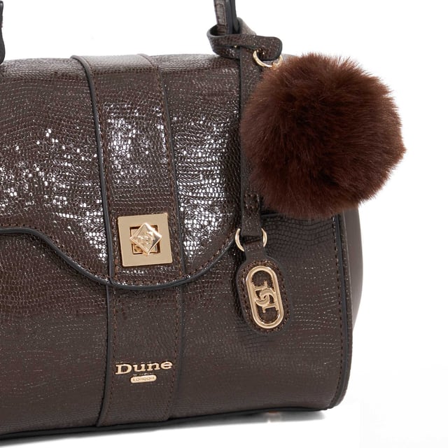 Dassios is the chic day bag that balances polish with practicality. Crafted with a contrasting textured side panel for a subtle style twist, it features a sleek turn-lock closure and a structured top handle for timeless appeal. Inside, the monogrammed lining reveals two spacious compartments ' one zipped for added security ' keeping your essentials neatly organised. Carry it by hand for a sophisticated look, or attach the optional long strap for a hands-free cross-body style. Finished with a removable logo and plush faux-fur pom-pom charm, Dassios is your go-to for effortless everyday elegance