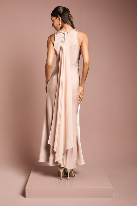 Elegant cowl neckline creates a graceful drape across the dcolletage
        Luxurious satin fabric with a subtle sheen catches the light beautifully
        Flowing chiffon drape detail adds movement and romantic flair
        Sleeveless design offers comfort whilst maintaining a sophisticated silhouette
        Ankle-length cut with a gentle flare creates an effortlessly elegant profile
    
    This stunning Coast bridesmaids dress combines timeless elegance with contemporary design elements. The sumptuous satin fabric creates a sleek silhouette whilst the cowl neckline adds a touch of classic sophistication. The chiffon drape detail flows gracefully from the back, creating movement and dimension as you walk down the aisle. Perfect for your role in the bridal party, this dress can be styled with delicate drop earrings and strappy heeled sandals as shown for a coordinated look that complements the bride without overshadowing her. The clean lines and fluid silhouette ensure comfort throughout the ceremony and reception, allowing you to focus on supporting the bride on her special day. Complete your bridesmaids ensemble with a small posy that echoes the bridal bouquet for a harmonious wedding party aesthetic.