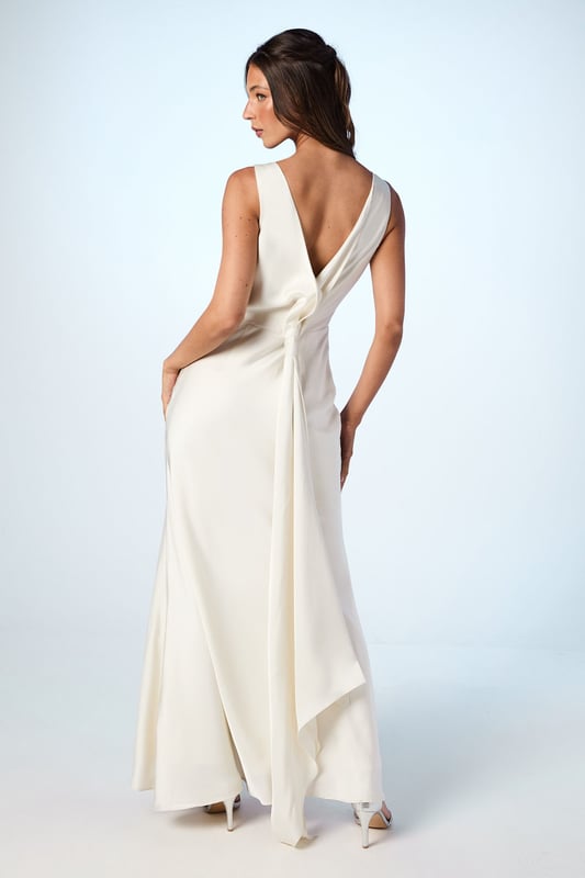 Elegant satin maxi dress with a sophisticated square neckline
        Striking V-back design with a dramatic sash detail that flows beautifully
        Figure-flattering silhouette with a floor-sweeping maxi length
        Sleeveless design perfect for formal wedding celebrations
        Smooth satin fabric creates a luxurious drape and refined finish
    
    This stunning Coast bridesmaid dress combines timeless elegance with contemporary design elements. The clean lines of the square neckline create a graceful frame for the dcolletage, whilst the dramatic V-back with flowing sash detail adds unexpected visual interest when you turn. The sleek silhouette skims the body beautifully before extending to a floor-length finish, creating a sophisticated and elongating effect. Style with delicate strappy heels and refined jewellery for a coordinated bridal party look. The versatile design allows for various styling options within your wedding colour palette, making it ideal for creating a cohesive yet distinctive bridesmaid ensemble. This dress strikes the perfect balance between understated refinement and special occasion glamour, ensuring you feel confident and elegant whilst supporting the bride on her special day.