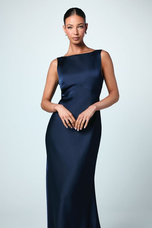 Elegant satin maxi dress with a sophisticated square neckline
        Striking V-back design with a dramatic sash detail that flows beautifully
        Figure-flattering silhouette with a floor-sweeping maxi length
        Sleeveless design perfect for formal wedding celebrations
        Smooth satin fabric creates a luxurious drape and refined finish
    
    This stunning Coast bridesmaid dress combines timeless elegance with contemporary design elements. The clean lines of the square neckline create a graceful frame for the dcolletage, whilst the dramatic V-back with flowing sash detail adds unexpected visual interest when you turn. The sleek silhouette skims the body beautifully before extending to a floor-length finish, creating a sophisticated and elongating effect. Style with delicate strappy heels and refined jewellery for a coordinated bridal party look. The versatile design allows for various styling options within your wedding colour palette, making it ideal for creating a cohesive yet distinctive bridesmaid ensemble. This dress strikes the perfect balance between understated refinement and special occasion glamour, ensuring you feel confident and elegant whilst supporting the bride on her special day.