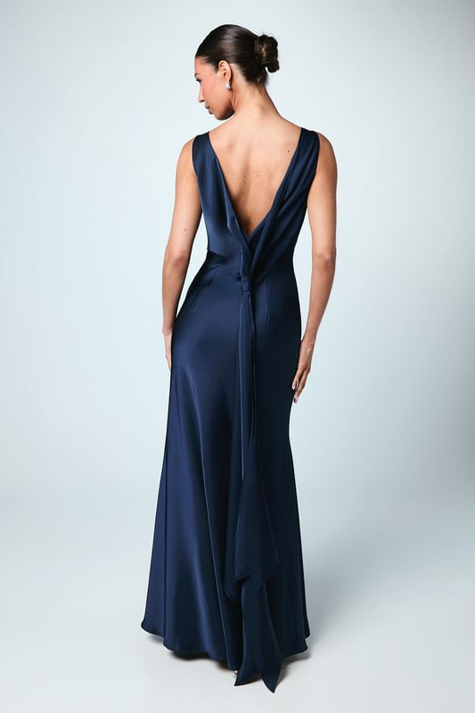 Elegant satin maxi dress with a sophisticated square neckline
        Striking V-back design with a dramatic sash detail that flows beautifully
        Figure-flattering silhouette with a floor-sweeping maxi length
        Sleeveless design perfect for formal wedding celebrations
        Smooth satin fabric creates a luxurious drape and refined finish
    
    This stunning Coast bridesmaid dress combines timeless elegance with contemporary design elements. The clean lines of the square neckline create a graceful frame for the dcolletage, whilst the dramatic V-back with flowing sash detail adds unexpected visual interest when you turn. The sleek silhouette skims the body beautifully before extending to a floor-length finish, creating a sophisticated and elongating effect. Style with delicate strappy heels and refined jewellery for a coordinated bridal party look. The versatile design allows for various styling options within your wedding colour palette, making it ideal for creating a cohesive yet distinctive bridesmaid ensemble. This dress strikes the perfect balance between understated refinement and special occasion glamour, ensuring you feel confident and elegant whilst supporting the bride on her special day.