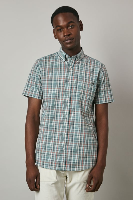Classic button-down collar for a refined casual look
        Short sleeves with neat hems perfect for warmer weather
        Traditional check pattern adds visual interest and versatility
        Chest pocket with subtle Maine brand detailing
        Regular fit with back pleat for enhanced comfort and movement
    
    This Maine short sleeve shirt showcases a timeless check pattern that brings a touch of sophistication to your summer wardrobe. The button-down collar maintains structure while keeping things casual, making it ideal for various daytime occasions. As seen on our model, pair this versatile shirt with light-coloured shorts and white trainers for an effortlessly stylish weekend look. The shirt works brilliantly for family barbecues, casual garden parties, or relaxed pub lunches with friends. For a smarter appearance, tuck it into chino trousers and add a canvas belt. The breathable fabric ensures comfort during warmer days, while the classic pattern ensures this piece will remain a staple in your collection for seasons to come. Perfect for packing on weekend getaways or summer holidays when you need an easy-to-style option that delivers on both comfort and style.