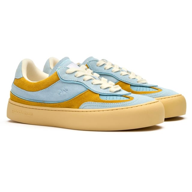 The Good News Lagoon trainers blend effortless style with eco-conscious design in a beautiful blue hue. Crafted from handmade deadstock suede with a distinctive stamped GN motif, these casual court-inspired shoes deliver laid-back sophistication. The chunky organic cotton laces add character, while recycled mesh lining ensures comfort all day. With their rubber sole providing reliable grip, these sustainable trainers prove that responsible fashion can be both chic and practicalâperfect for the environmentally aware woman who refuses to compromise on style.