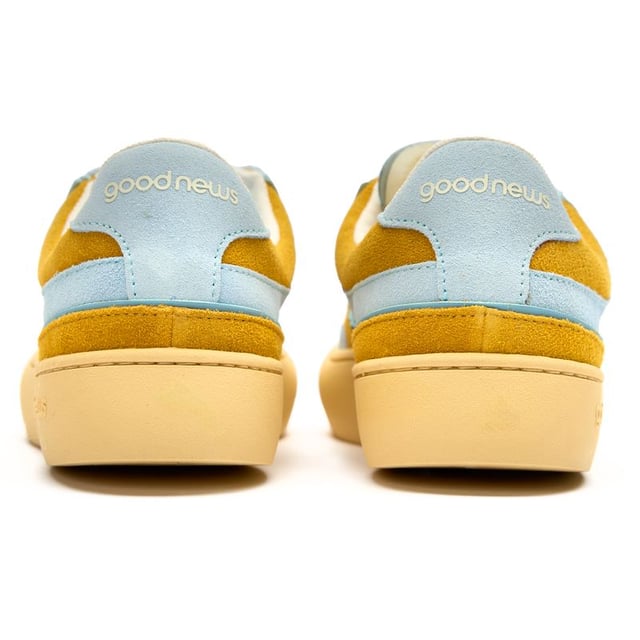 The Good News Lagoon trainers blend effortless style with eco-conscious design in a beautiful blue hue. Crafted from handmade deadstock suede with a distinctive stamped GN motif, these casual court-inspired shoes deliver laid-back sophistication. The chunky organic cotton laces add character, while recycled mesh lining ensures comfort all day. With their rubber sole providing reliable grip, these sustainable trainers prove that responsible fashion can be both chic and practicalâperfect for the environmentally aware woman who refuses to compromise on style.