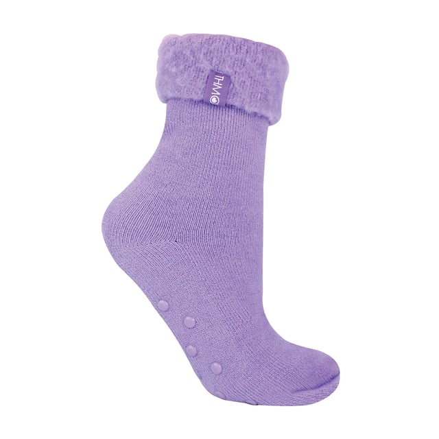 THMO Ladies Thermal Turnover Bed Socks: Embrace the cosy comfort of our THMO Bed Socks, your perfect pair for those chilly winter days and nights. As the temperature drops, it's essential to keep yourself warm while also saving on heating bills. Treat yourself to the ultimate warmth without compromising your budget. Crafted using a specially selected heavy bulk acrylic yarn, these socks possess exceptional thermal qualities that will keep your feet cosy even in the coldest of winters. To enhance their insulating properties, the socks have been double brushed on the inside, creating a plush and velvety texture that maximises warmth and provides softness against your skin. By effectively trapping warm air and enveloping your feet in comfort, these bed socks are the perfect choice for those moments of indoor relaxation and tranquillity. . An innovative anti-slip grip has been designed onto the foot of the sock in order to prevent you from slipping on surfaces such as hard wooden floors or kitchen tiles. . These THMO thermal bed socks are available in 3 colours: Purple, Pink & Blue, with dotted grippers. They are available in one size Ladies 4-8 UK. They are made from 93% Acrylic, 6% Polyamide & 1% Elastane. They are also safely machine washable. Extra Product Details: THMO Slipper Bed Socks Double Brushed Inner Thick & Warm Hand Linked Toe Turnover Top 3 Colour Options