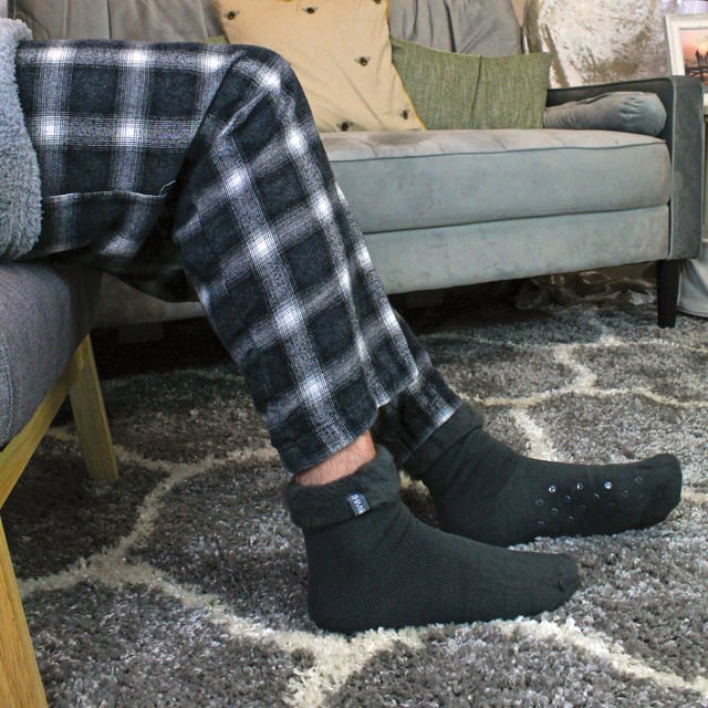 THMO Men’s Thermal Turnover Bed Socks: Embrace the cosy comfort of our THMO Bed Socks, your perfect pair for those chilly winter days and nights. As the temperature drops, it's essential to keep yourself warm while also saving on heating bills. Treat yourself to the ultimate warmth without compromising your budget. Crafted using a specially selected heavy bulk acrylic yarn, these socks possess exceptional thermal qualities that will keep your feet cosy even in the coldest of winters. . An innovative anti-slip grip has been designed onto the foot of the sock in order to prevent you from slipping on surfaces such as hard wooden floors or kitchen tiles. It is a simple but effective dotted design on the foot of the sock. By effectively trapping warm air and enveloping your feet in comfort, these bed socks are the perfect choice for those moments of indoor relaxation and tranquillity. The THMO badge is also heat transferred onto the side of the sock. These THMO thermal bed socks are available in 3 colours: Black, Navy & Charcoal, with dotted grippers. They are available in one size Men’s 6-11 UK. They are made from 93% Acrylic, 6% Polyamide & 1% Elastane. They are also safely machine washable. Extra Product Details: THMO Slipper Bed Socks Double Brushed Inner Thick & Warm Hand Linked Toe Turnover Top Non-Slip Grippers 3 Colour Options Men’s One Size 6-11 UK Machine Washable