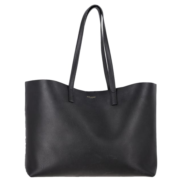 VINTAGE, RRP AS NEW
Effortlessly chic and endlessly practical, this Saint Laurent East/West tote is the definition of understated luxury. Crafted in Italy from supple black textured leather, it features a roomy, unstructured silhouette that fits everything from your laptop to a makeup bag. A gleaming gold 'YSL' charm and detachable coin pouch complete the polished design. The perfect carryall for your workday, weekend, or in-flight essentials.


Saint Laurent East/West Large Textured Tote in Black Leather
Condition: Very good
Signs of wear: No retail tag, Minor sign of wear or markings., Lightly used but very well maintained. Minor creasing, light worn corners, light scratches.
Packaging: None
Color: black
Material: Leather | leather
Size: One Size | One Size
Measurements: Width: 470; Height: 150; Length: 280; Handle drop: 120; Strap length: 300
SKU: NAPPUGBBA516705W