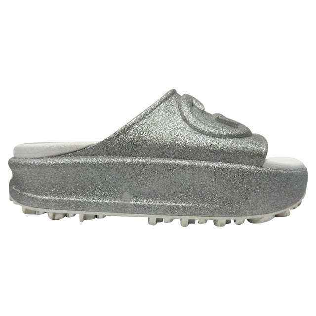 VINTAGE, RRP AS NEW
Step into effortless glamour with the Gucci GG Logo Glittered Slide Sandals in Silver Rubber — where iconic luxury meets eye-catching sparkle. These chic slides elevate any casual look, perfect for adding a touch of shine to your weekend outfit. **Styling tip:** Pair them with cropped denim and a sleek white blouse for an effortlessly polished vibe that highlights the sandals’ dazzling silver glitter.

 Gucci GG Logo Glittered Slide Sandals in Silver Rubber

Condition: Very good
Signs of wear: Minor markings, Lightly used but very well maintained. Minor mark at soles & creasing, light scuffing at the soles and heels.
Packaging: Box
Color: Metallic | silver
Material: Rubber
Size: IT | 34
Measurements: Insole length: 250 mm
SKU: TONPUGBSH524165W