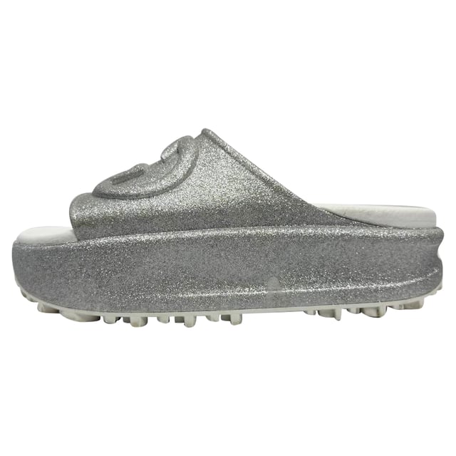 VINTAGE, RRP AS NEW
Step into effortless glamour with the Gucci GG Logo Glittered Slide Sandals in Silver Rubber — where iconic luxury meets eye-catching sparkle. These chic slides elevate any casual look, perfect for adding a touch of shine to your weekend outfit. **Styling tip:** Pair them with cropped denim and a sleek white blouse for an effortlessly polished vibe that highlights the sandals’ dazzling silver glitter.

 Gucci GG Logo Glittered Slide Sandals in Silver Rubber

Condition: Very good
Signs of wear: Minor markings, Lightly used but very well maintained. Minor mark at soles & creasing, light scuffing at the soles and heels.
Packaging: Box
Color: Metallic | silver
Material: Rubber
Size: IT | 34
Measurements: Insole length: 250 mm
SKU: TONPUGBSH524165W