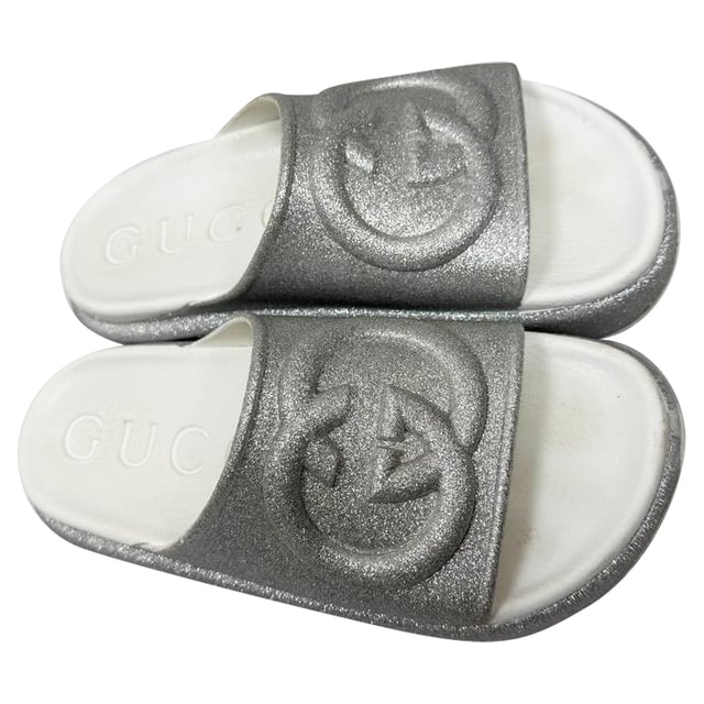 VINTAGE, RRP AS NEW
Step into effortless glamour with the Gucci GG Logo Glittered Slide Sandals in Silver Rubber — where iconic luxury meets eye-catching sparkle. These chic slides elevate any casual look, perfect for adding a touch of shine to your weekend outfit. **Styling tip:** Pair them with cropped denim and a sleek white blouse for an effortlessly polished vibe that highlights the sandals’ dazzling silver glitter.

 Gucci GG Logo Glittered Slide Sandals in Silver Rubber

Condition: Very good
Signs of wear: Minor markings, Lightly used but very well maintained. Minor mark at soles & creasing, light scuffing at the soles and heels.
Packaging: Box
Color: Metallic | silver
Material: Rubber
Size: IT | 34
Measurements: Insole length: 250 mm
SKU: TONPUGBSH524165W