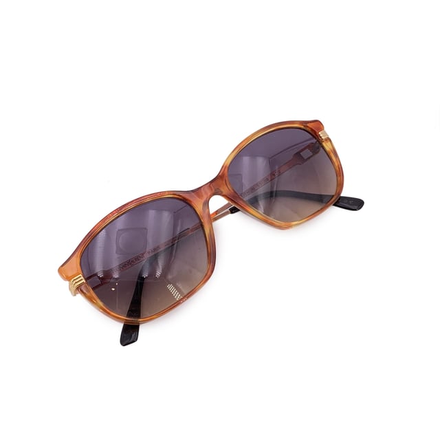 VINTAGE, RRP AS NEW
Step into timeless sophistication with these vintage Yves Saint Laurent sunglasses, model TITHON. Crafted in France, these shades embody the quiet elegance and bold spirit of '90s high fashion. The rich brown rectangular acetate frame strikes a perfect balance between structure and style, while grey gradient lenses offer just the right touch of mystery.  With a frame width of 140 mm and matching temple length, they offer a comfortable yet statement-making fit. A rare gem for true vintage collectors, the TITHON model reflects an era when every accessory was a piece of art-and these sunglasses are no exception.  In excellent vintage Condition Rating: A - EXCELLENTCondition Details: Gently Used. Lenses and frame in excellent condition. Please check the images carefully. Some show arrows indicating any evident defect. Please ask if you need to know more details or if you have any doubts. Generic case always included, please ask for availability of original case. Glasses maximum Width: 140mm Glasses Temple 140mm Glasses maximum lens width: 55mm Glasses maximum lens 42mm Glasses bridge width: 18mm Measurments:  width: 140 mm height: 42 mm