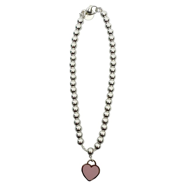 VINTAGE, RRP AS NEW
Effortlessly elegant, the Return to Tiffany Enamel Bead Bracelet is a modern take on a timeless icon. Inspired by the original 1969 key ring, this piece features polished silver beads and a signature engraved tag detailed with a pop of pink enamel. Understated yet instantly recognizable, it's the kind of bracelet that elevates your everyday and adds a touch of Tiffany charm to any look.


Tiffany & Co. Return To Tiffany Enamel Bead Bracelet in Silver Metal
Condition: Excellent
Signs of wear:  No sign of wear.
Packaging: None
Color: silver
Material: Metal
Size: One Size | One Size
Measurements: 
SKU: MRPPUGBOT520389M