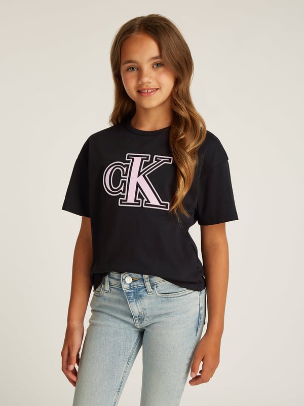 Introducing the Girls Monogram Flock Boxy T-Shirt in Black by Calvin Klein. Crafted for the discerning young fashionista for SS2025, this top merges cutting-edge style with peak comfort. Explore its unique features Distinctive Monogram Flock Design Elevating the casual with luxury, perfect for making a sleek statement. Supreme Comfort Soft fabrics ensure all-day ease for endless adventures. Versatile Style Easily pairs with any ensemble, enhancing your girl's wardrobe.Revitalise her collection with this exquisite piece today!