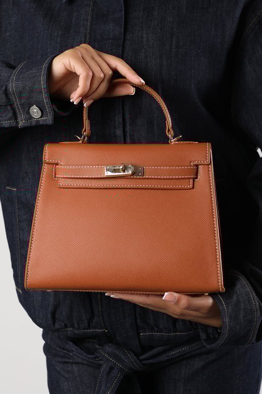 Elevate your everyday ensemble with this Lluvia Top Handle Satchel Mini Tote Bag, a timeless choice for modern elegance. Featuring a structured silhouette and refined grain-textured finish, this handbag blends style and practicality effortlessly. The polished gold-tone turn-lock closure adds a touch of sophistication. Ideal for work or weekend outings, it’s compact yet roomy enough for your essentials. Key Features: • Material: Textured faux leather with contrast stitching • Dimensions: 25cm (L) x 20cm (H) x 11cm (W) • Fastening: Gold-tone turn-lock flap closure • Detail: Minimalist top handle design with structured base and sleek finish 
