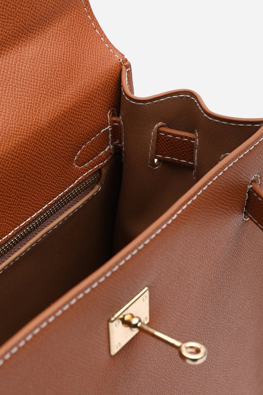 Elevate your everyday ensemble with this Lluvia Top Handle Satchel Mini Tote Bag, a timeless choice for modern elegance. Featuring a structured silhouette and refined grain-textured finish, this handbag blends style and practicality effortlessly. The polished gold-tone turn-lock closure adds a touch of sophistication. Ideal for work or weekend outings, it’s compact yet roomy enough for your essentials. Key Features: • Material: Textured faux leather with contrast stitching • Dimensions: 25cm (L) x 20cm (H) x 11cm (W) • Fastening: Gold-tone turn-lock flap closure • Detail: Minimalist top handle design with structured base and sleek finish 