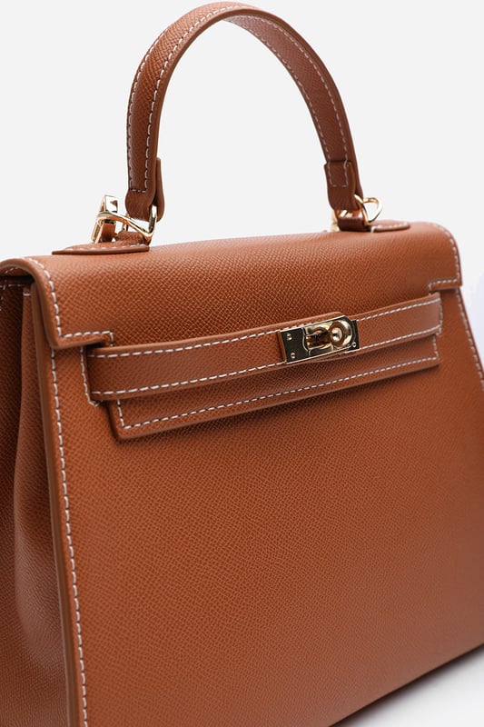 Elevate your everyday ensemble with this Lluvia Top Handle Satchel Mini Tote Bag, a timeless choice for modern elegance. Featuring a structured silhouette and refined grain-textured finish, this handbag blends style and practicality effortlessly. The polished gold-tone turn-lock closure adds a touch of sophistication. Ideal for work or weekend outings, it’s compact yet roomy enough for your essentials. Key Features: • Material: Textured faux leather with contrast stitching • Dimensions: 25cm (L) x 20cm (H) x 11cm (W) • Fastening: Gold-tone turn-lock flap closure • Detail: Minimalist top handle design with structured base and sleek finish 