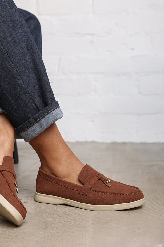 Wheres That From Womens 'Pegasus' Slip On Trim Loafers With Accessory Detailing Stay effortlessly chic in our Pegasus Slip On Trim Loafers, crafted in soft faux suede with a playful front accessory. Designed for everyday elegance, these loafers feature a cushioned memory foam insole and breathable lining for all-day comfort. The slip-on design and rubber sole offer ease and traction, making them perfect for work, weekends, or casual evenings out. Key Features: • Material: Faux suede upper with breathable, odor-resistant foam lining • Design: Flat dolly sliders with charm accessory detail • Closure: Easy slip-on design
