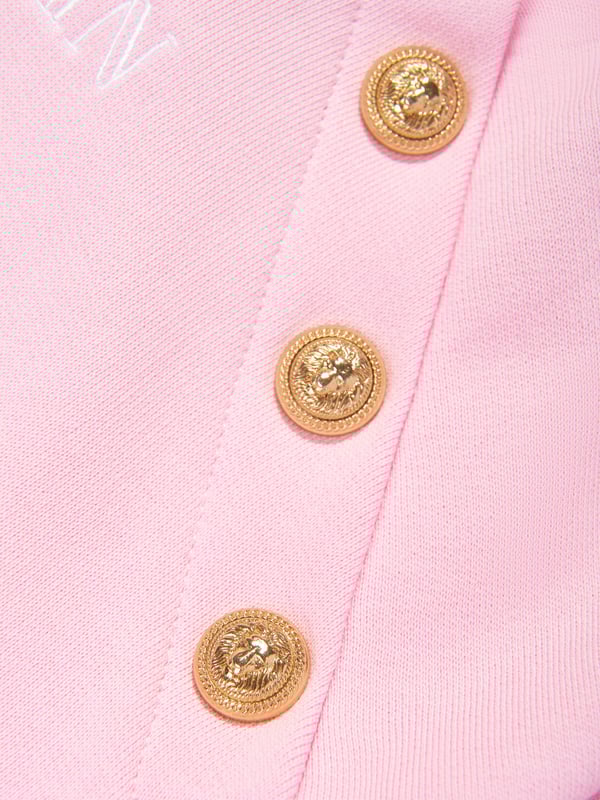 Balmain Girls Logo Hoodie in Pink Balmain embody distinctive Parisian sensibilities in their immaculate designs. This girls pink hoodie is reflective of the label's passion for raw innovation. Made in the finest cotton jersey with gold embellished buttons and Balmain Paris embroidered print. Ribbed HemCuffs 100 Cotton Trim 95 Cotton, 5 Elastane Embroidery 100 Polyester